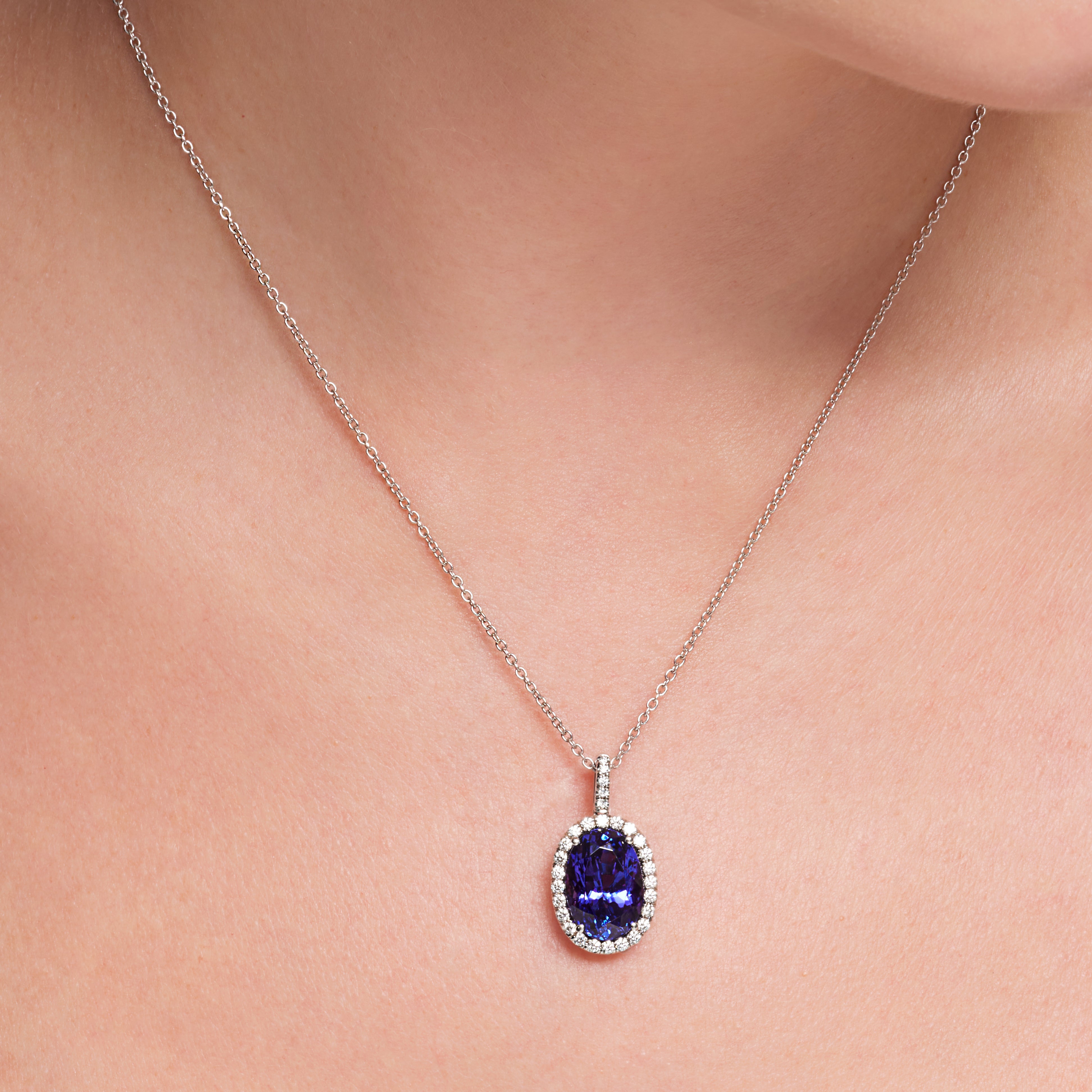 Oval Shape Tanzanite Diamond Halo Pendant In 18 Karat White Gold